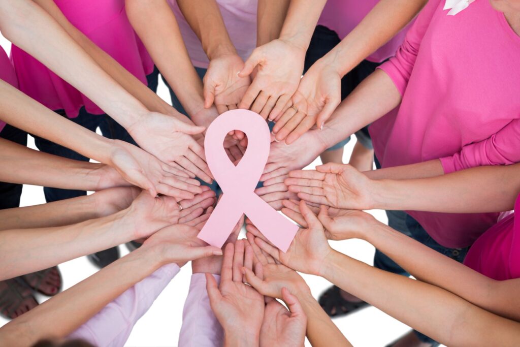 Group of hands holding a pink ribbon 